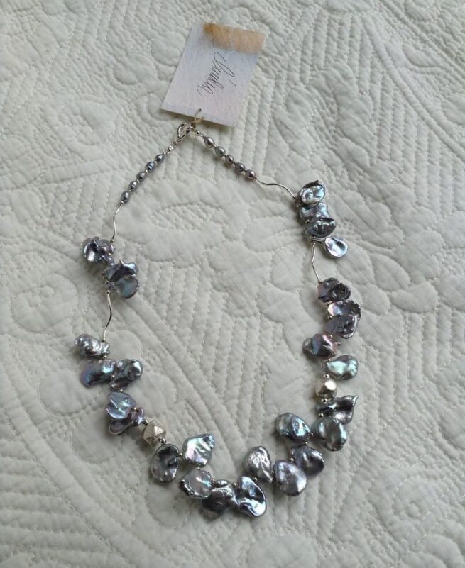 collana perle grigie Armonia argento intera distesa su stoffa chiara