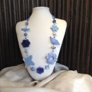 collana azzurra fiori ceramica a mano di nome Ginevra busto frontale sfondo nero