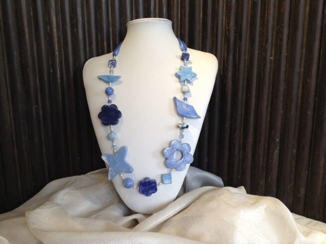 collana azzurra fiori ceramica a mano di nome Ginevra busto frontale sfondo nero