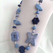 collana azzurra fiori ceramica a mano di nome Ginevra su busto lato destro