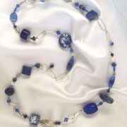 collana blu lunga pietre dure ceramica a mano nome Onda distesa lunga su seta bianca