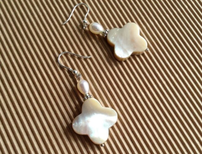 orecchini madreperla avorio forma fiore perle argento Cipria sfondo carta avana rigata