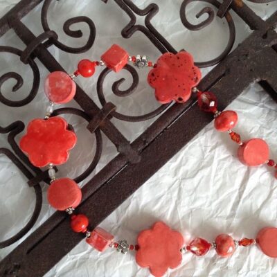 collana rossa fiori ceramica nome Lavinia distesa su cornice ferro particolare