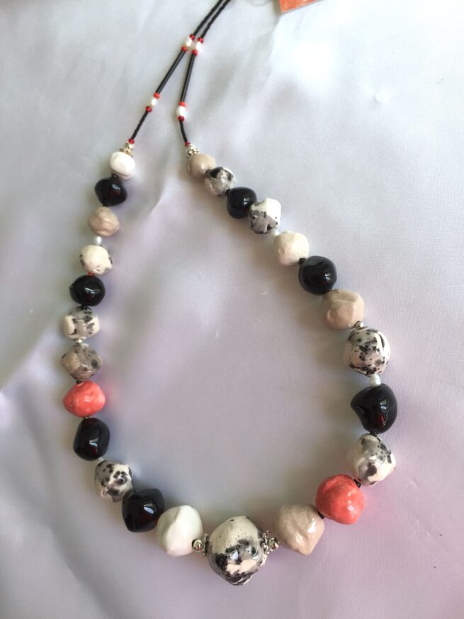 collana bianca nera rossa ceramica nome Milan Style distesa su seta bianca