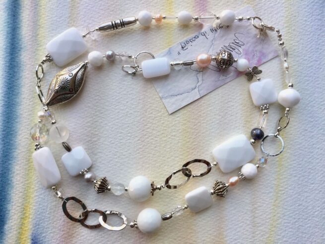 collana bianca lunga agata perle cristalli nome Fiocco di neve distesa su quadro chiaro
