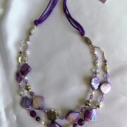 collana viola madreperla due fili di nome Luminosa Viola distesa sfondo stoffa bianca