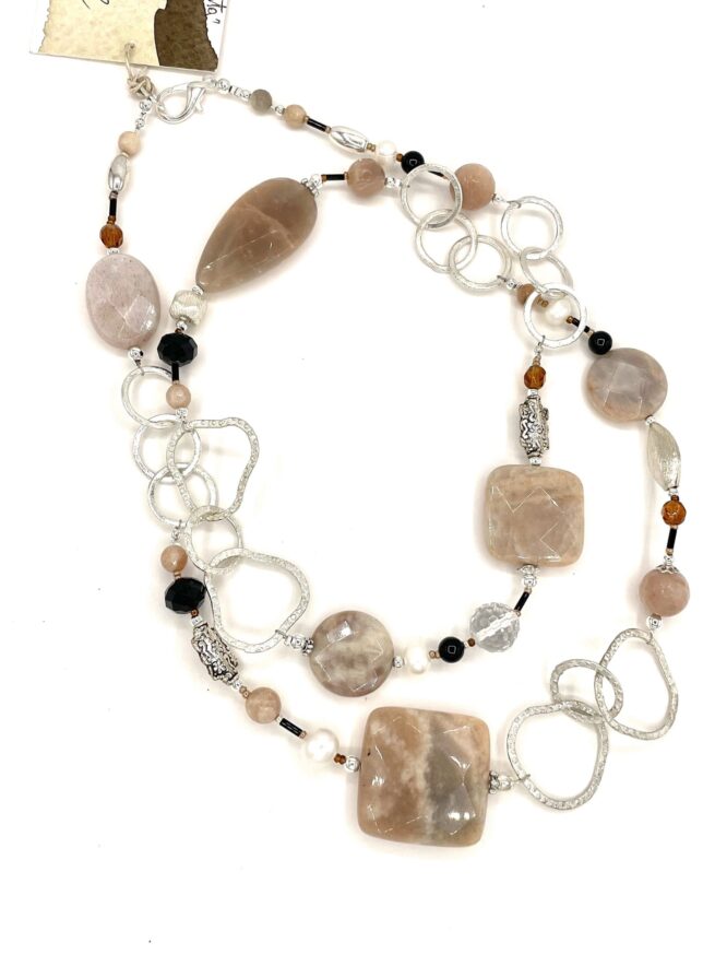 collana marrone lunga pietra luna onice nome noce moscata distesa doppia sfondo bianco puro
