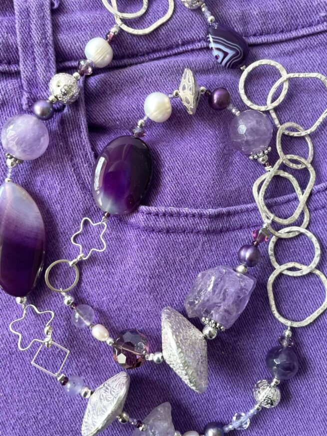 collana viola ametista agata chiamata Nanette distesa sfondo viola