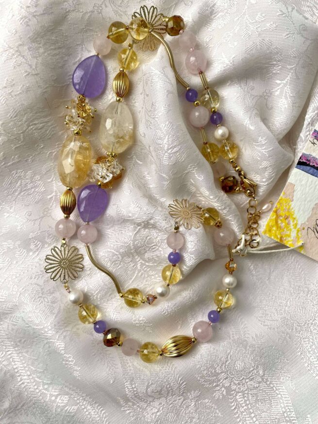 collana oro lilla rosa citrino agata chiamata Oro di Napoli distesa su seta bianca