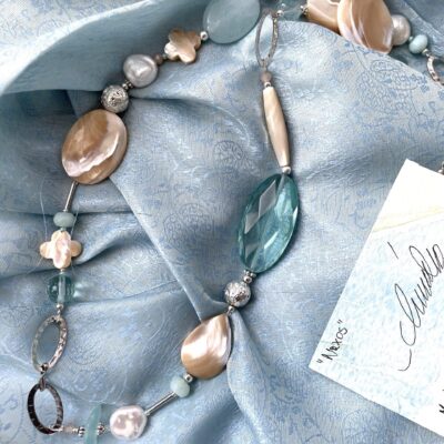collana beige-verde acqua madreperla ossidiana chiamata Naxos distesa su sciarpa azzurra