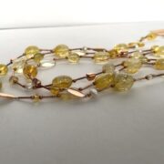 collana chiamata Color Oro a 3 fili quarzo cristallo distesa vista laterale