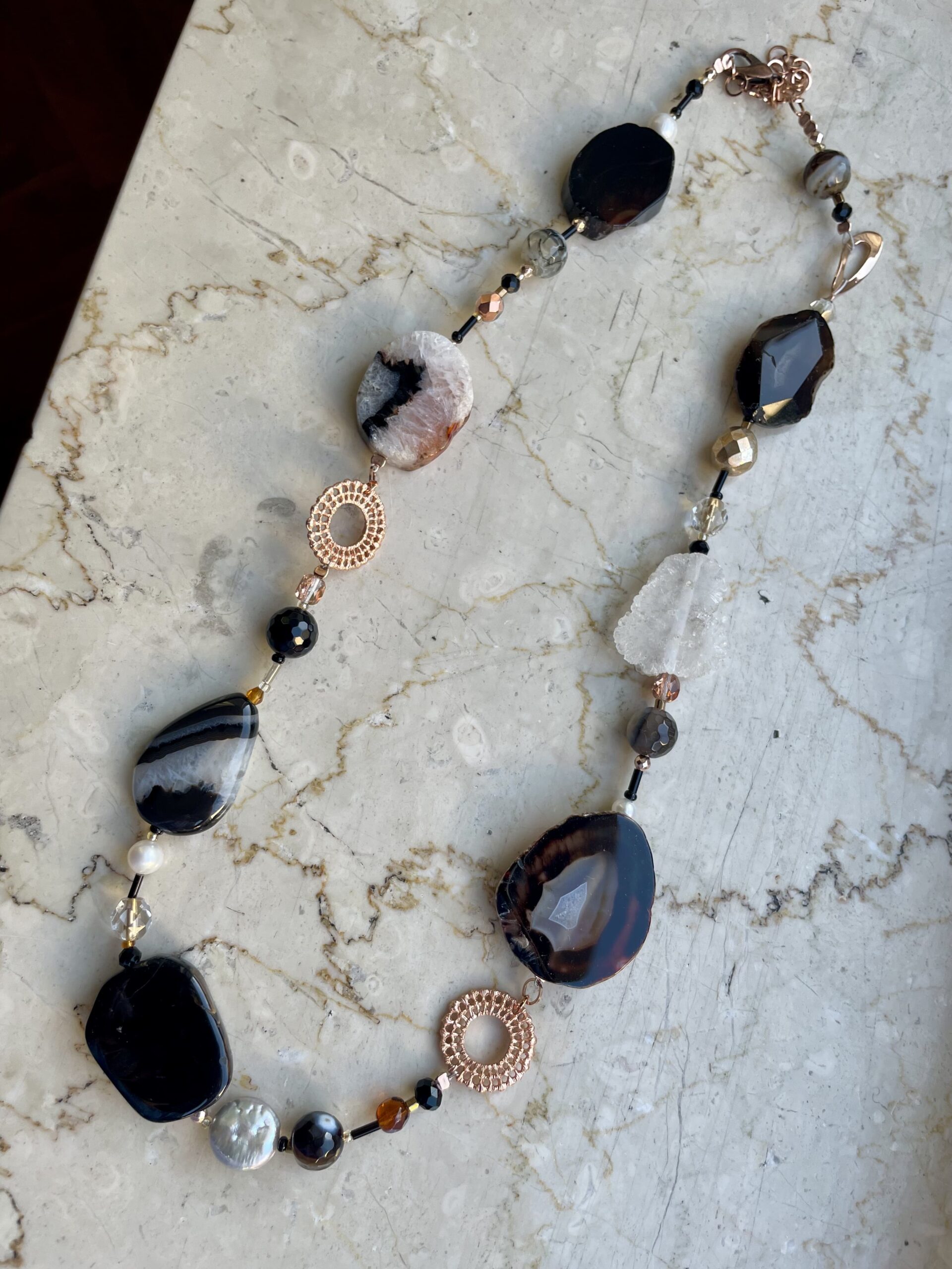 collana nera/bianca pietre dure di nome Venise distesa su marmo